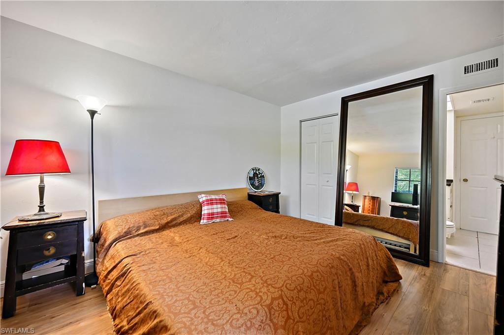 938 Augusta Boulevard, Unit D937 Naples, FL 34113 - Photo 21 of 27 a bedroom with a bed and lamp