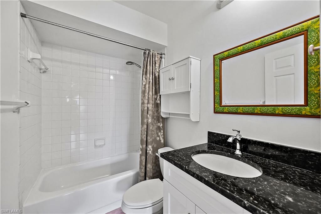 938 Augusta Boulevard, Unit D937 Naples, FL 34113 - Photo 23 of 27 a bathroom with a granite countertop sink mirror toilet and a bathtub
