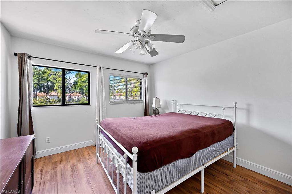 938 Augusta Boulevard, Unit D937 Naples, FL 34113 - Photo 24 of 27 a bed room with a bed and a chandelier