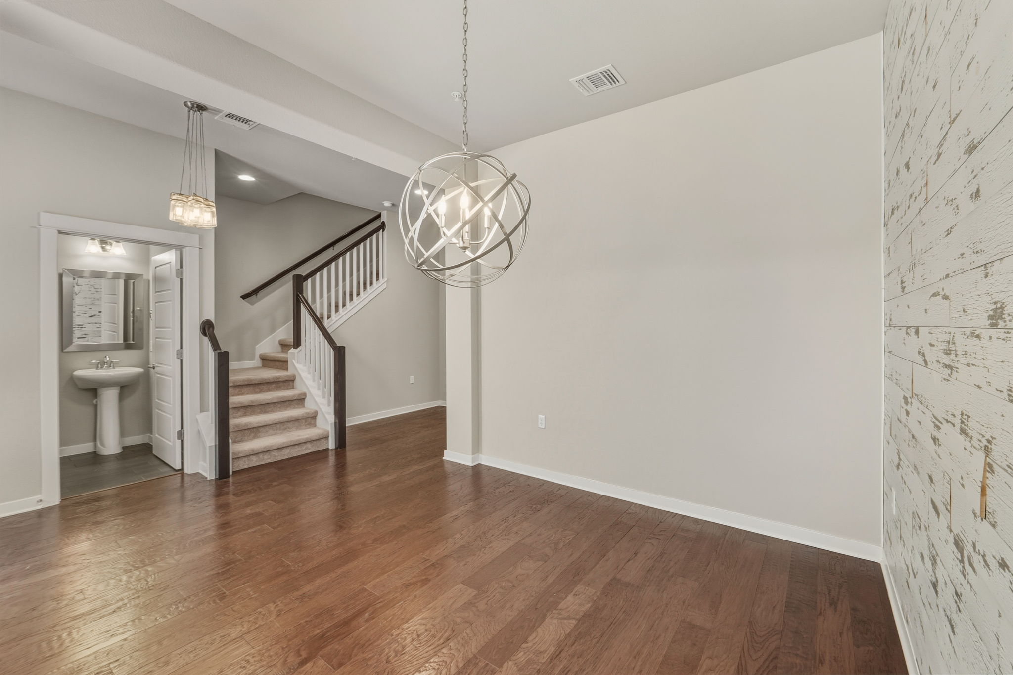 3919 Vaughan Street Austin, TX 78723 - Photo 5 of 40 Rich hardwood flooring guides visitors through this luminous interior, featuring an elegant staircase and a powder room.