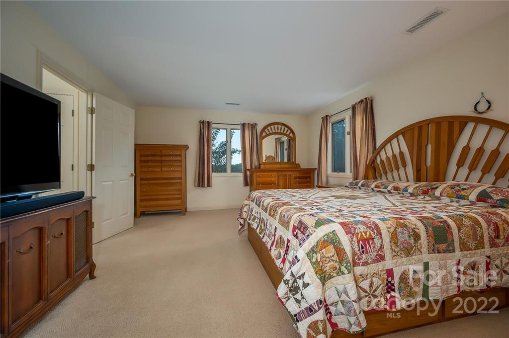 161 Walker Road Mill Spring, NC 28756 - Photo 17 of 47 a bedroom with a bed and a flat screen tv in it
