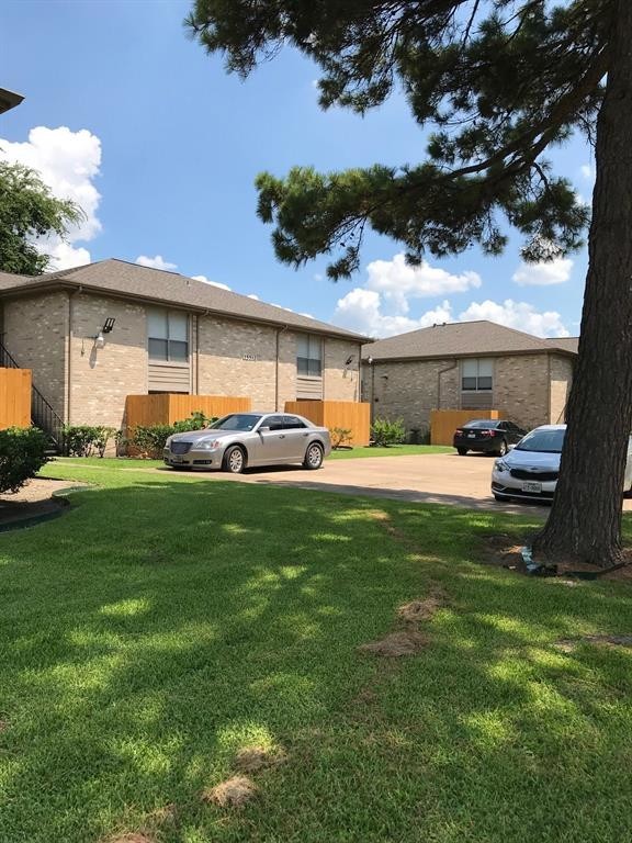 1947 Greenbriar Colony Drive, Unit 15502C Houston, TX 77032 - Photo 8 of 12 a row of car parked in front of yellow house