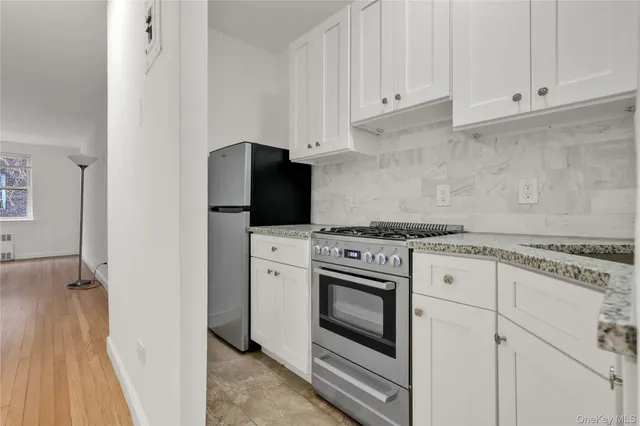 a kitchen with granite countertop white cabinets and white appliances