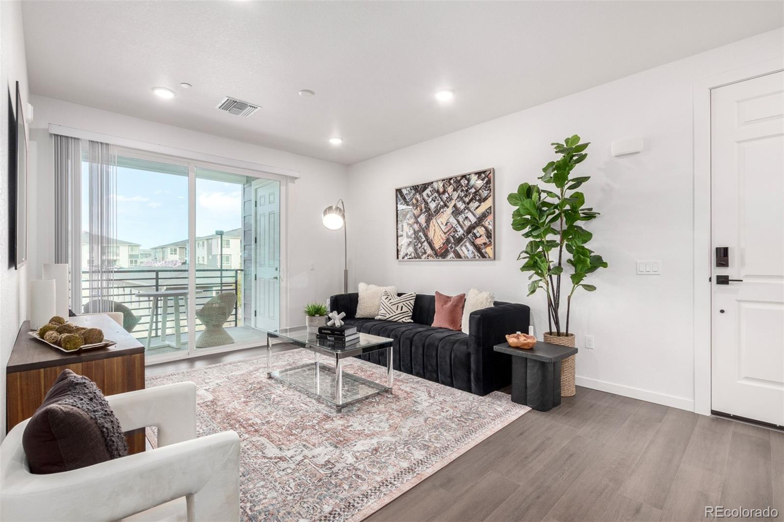 6153 North Ceylon Street, Unit 204 Denver, CO 80249 - Photo 2 of 22 a living room with furniture potted plant and a large window