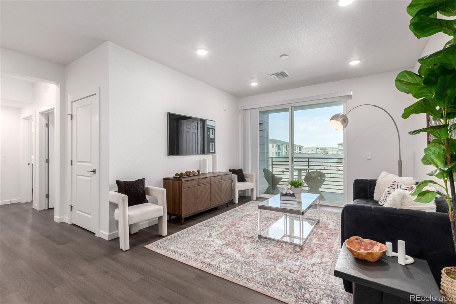 6153 North Ceylon Street, Unit 204 Denver, CO 80249 - Photo 3 of 22 a living room with furniture and a flat screen tv