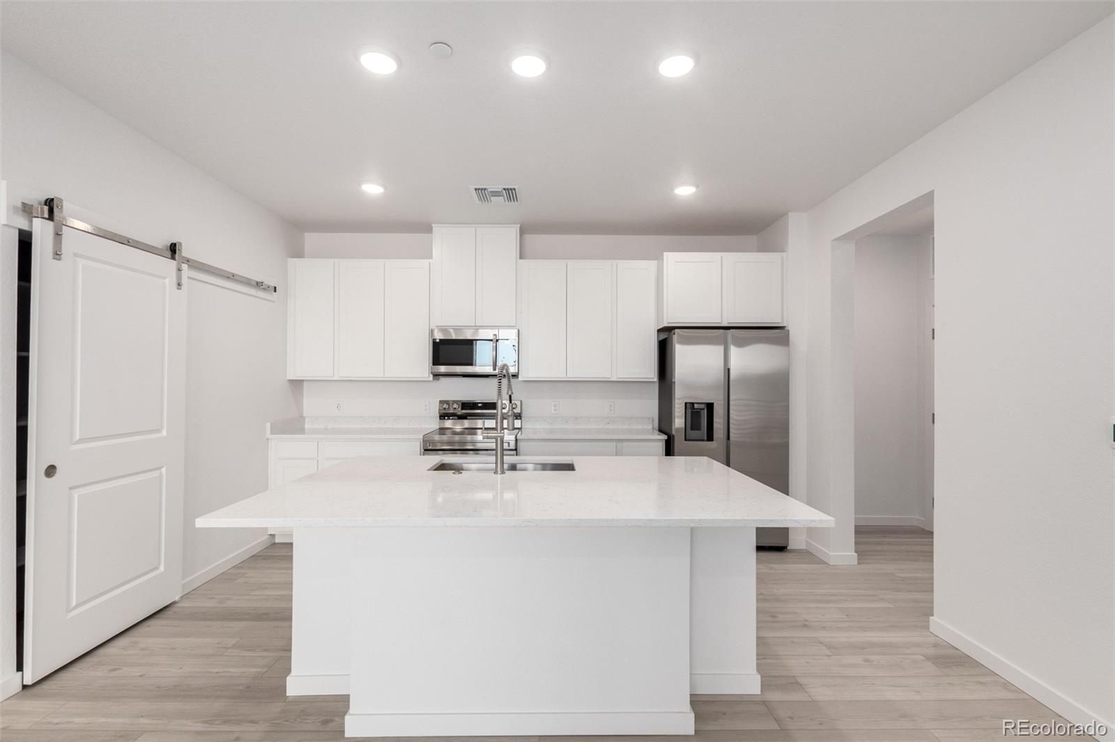6153 North Ceylon Street, Unit 204 Denver, CO 80249 - Photo 4 of 22 a kitchen with stainless steel appliances a refrigerator sink and microwave