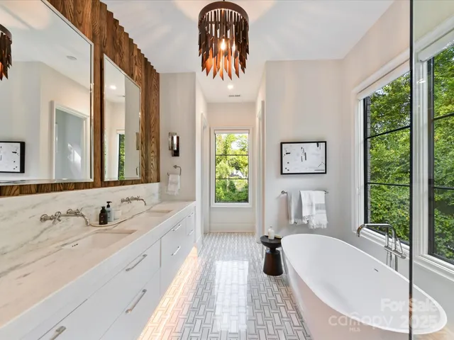 a spacious en suite bathroom with a granite countertop tub and a large window
