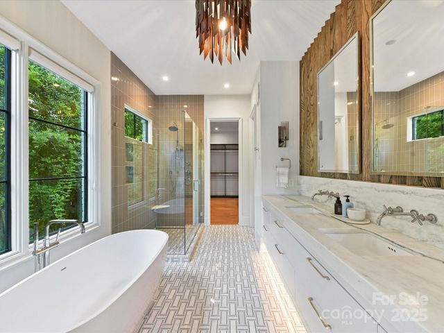 a spacious bathroom with a double vanity sink a large mirror and shower