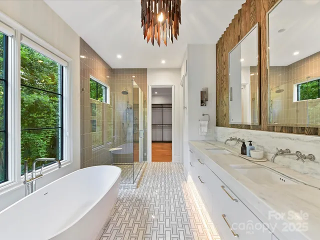 a spacious bathroom with a double vanity sink a large mirror and shower