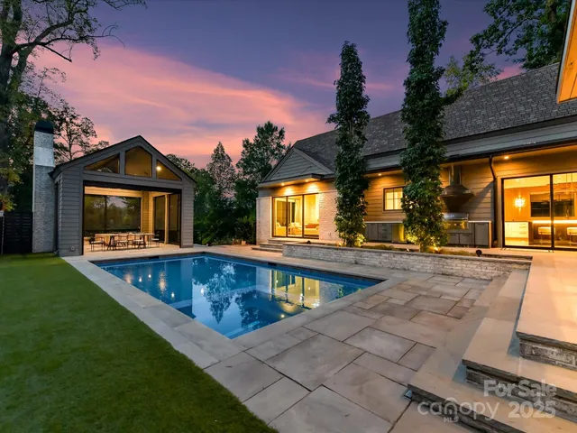 a view of a house with swimming pool and sitting area