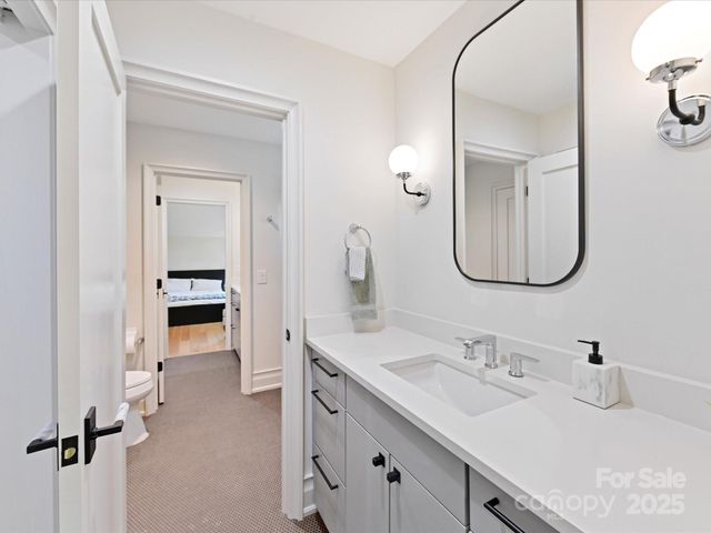 a en suite bathroom with a double vanity sink and a mirror