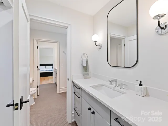 a en suite bathroom with a double vanity sink and a mirror