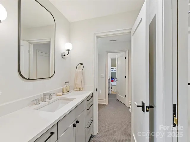a en suite bathroom with a double vanity sink and a mirror