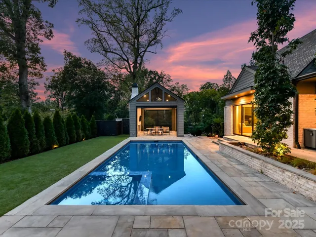 a view of backyard with swimming pool and outdoor seating