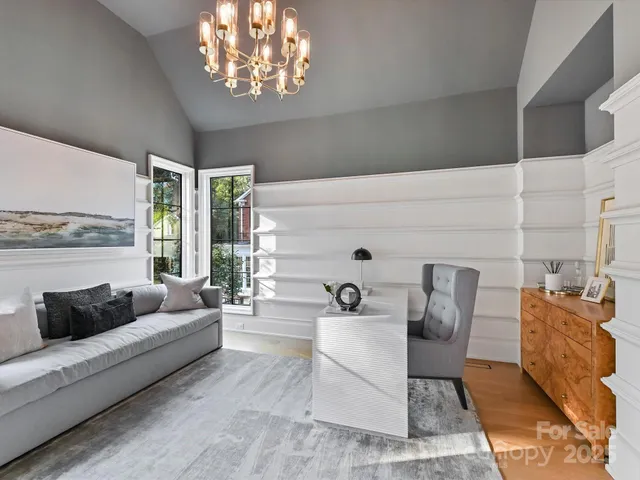 a living room with furniture and a chandelier