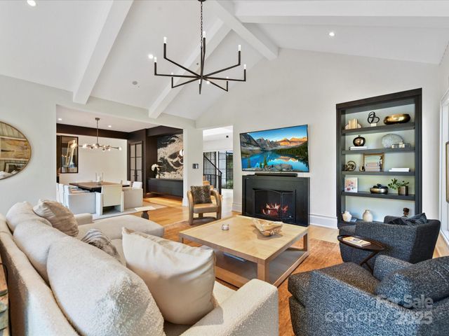 a living room with fireplace furniture and a chandelier