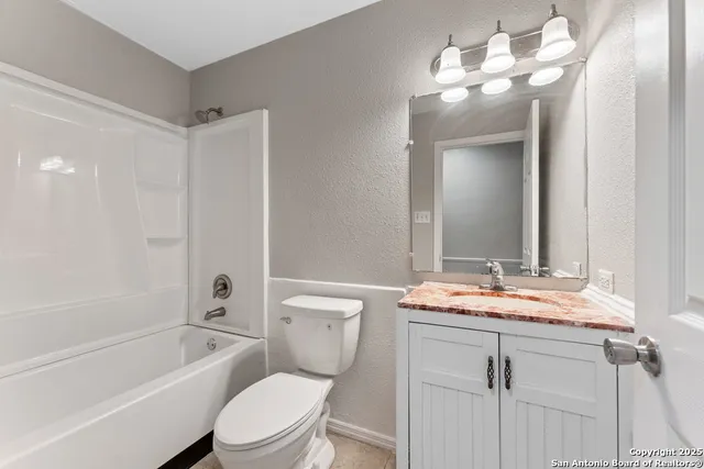 a bathroom with a toilet a sink a tub and mirror
