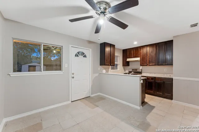 a kitchen with stainless steel appliances granite countertop a refrigerator a sink dishwasher a stove with wooden cabinets and floor