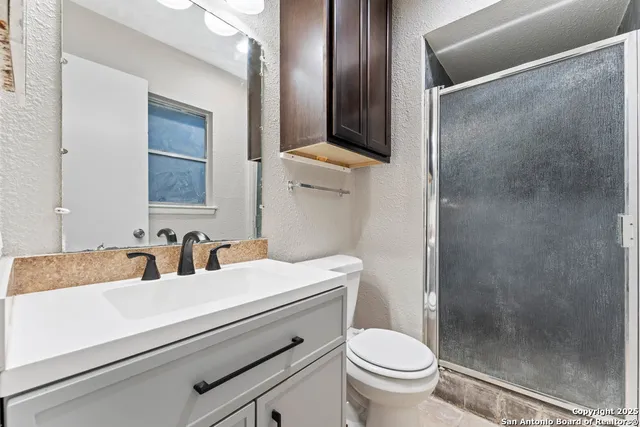a bathroom with a sink toilet and shower