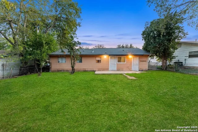 a front view of house with garden and trees