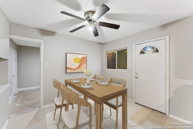 a view of a dining room with furniture and a chandelier fan