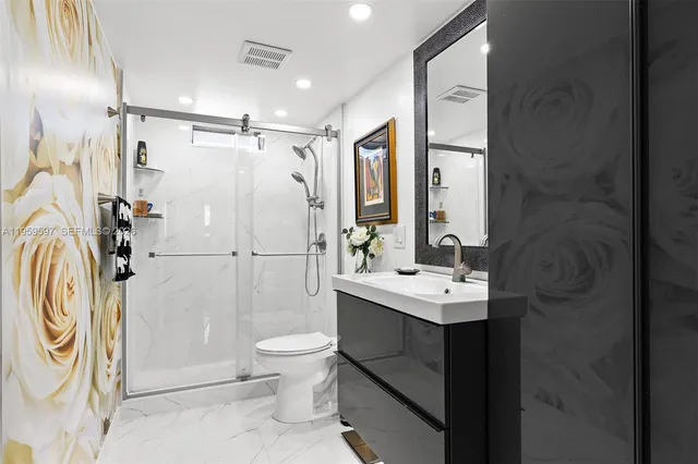 a bathroom with a sink a toilet and shower