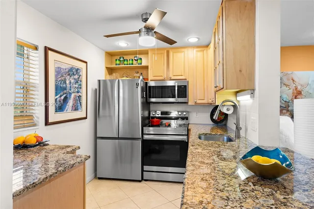 a kitchen with stainless steel appliances granite countertop a refrigerator sink and stove