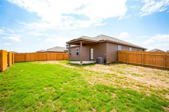 a view of a house with a yard and wooden fence