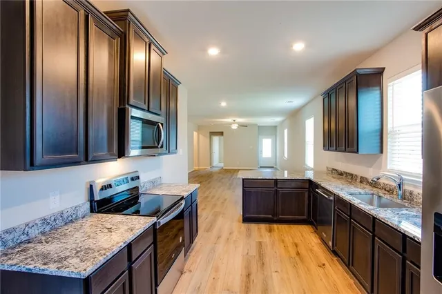 a large kitchen with kitchen island granite countertop wooden cabinets and a granite counter tops