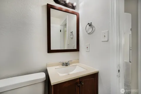 a bathroom with a toilet sink and mirror