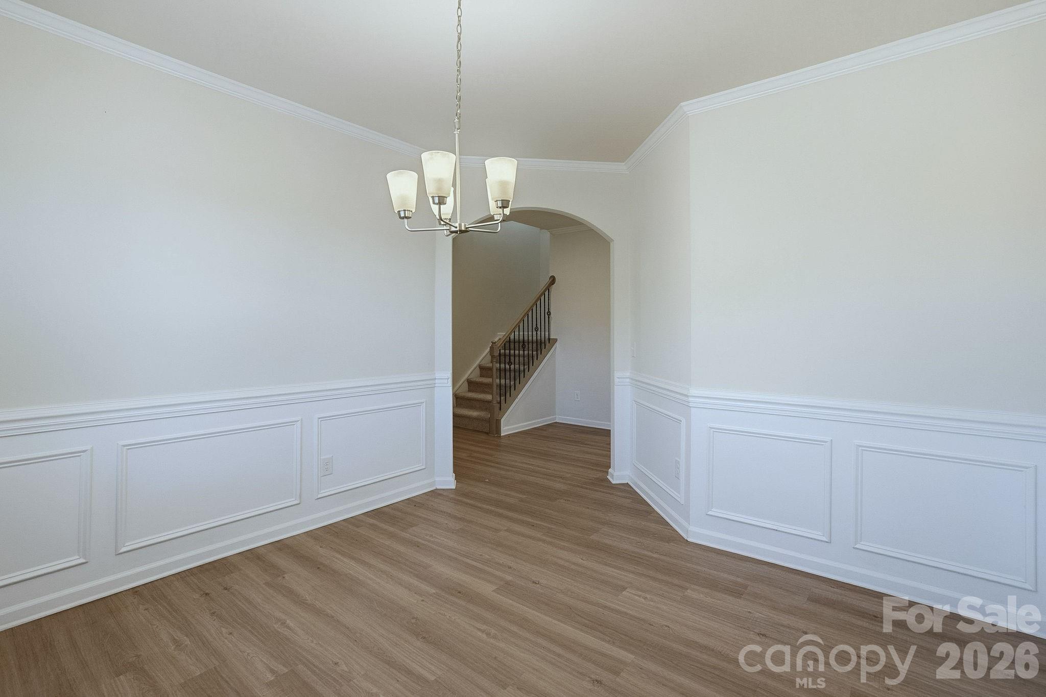 124 Tackle Troutman, NC 28166 - Photo 15 of 44 a view of empty room with wooden floor and chandelier