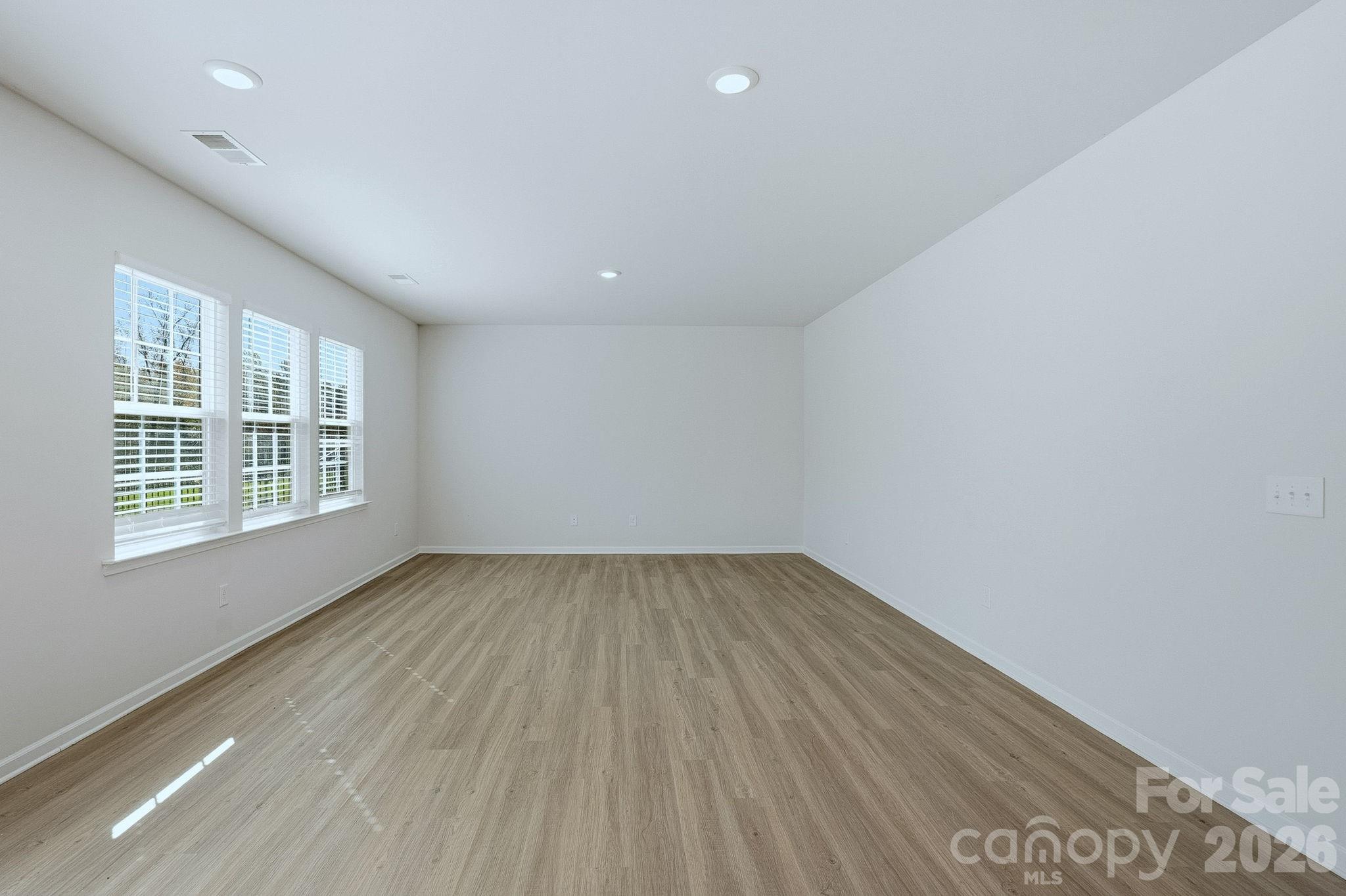 124 Tackle Troutman, NC 28166 - Photo 17 of 44 an empty room with wooden floor and windows