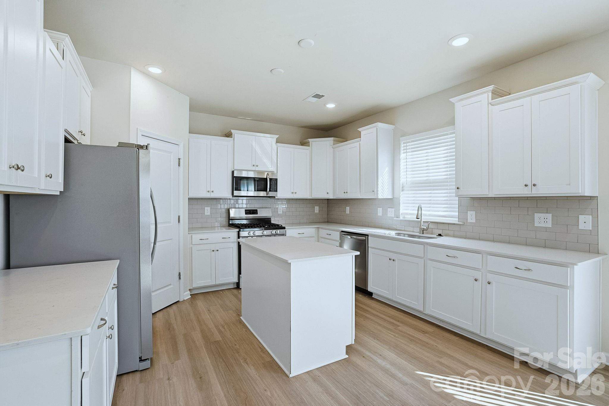 124 Tackle Troutman, NC 28166 - Photo 18 of 44 a kitchen with cabinets stainless steel appliances a sink and wooden floor