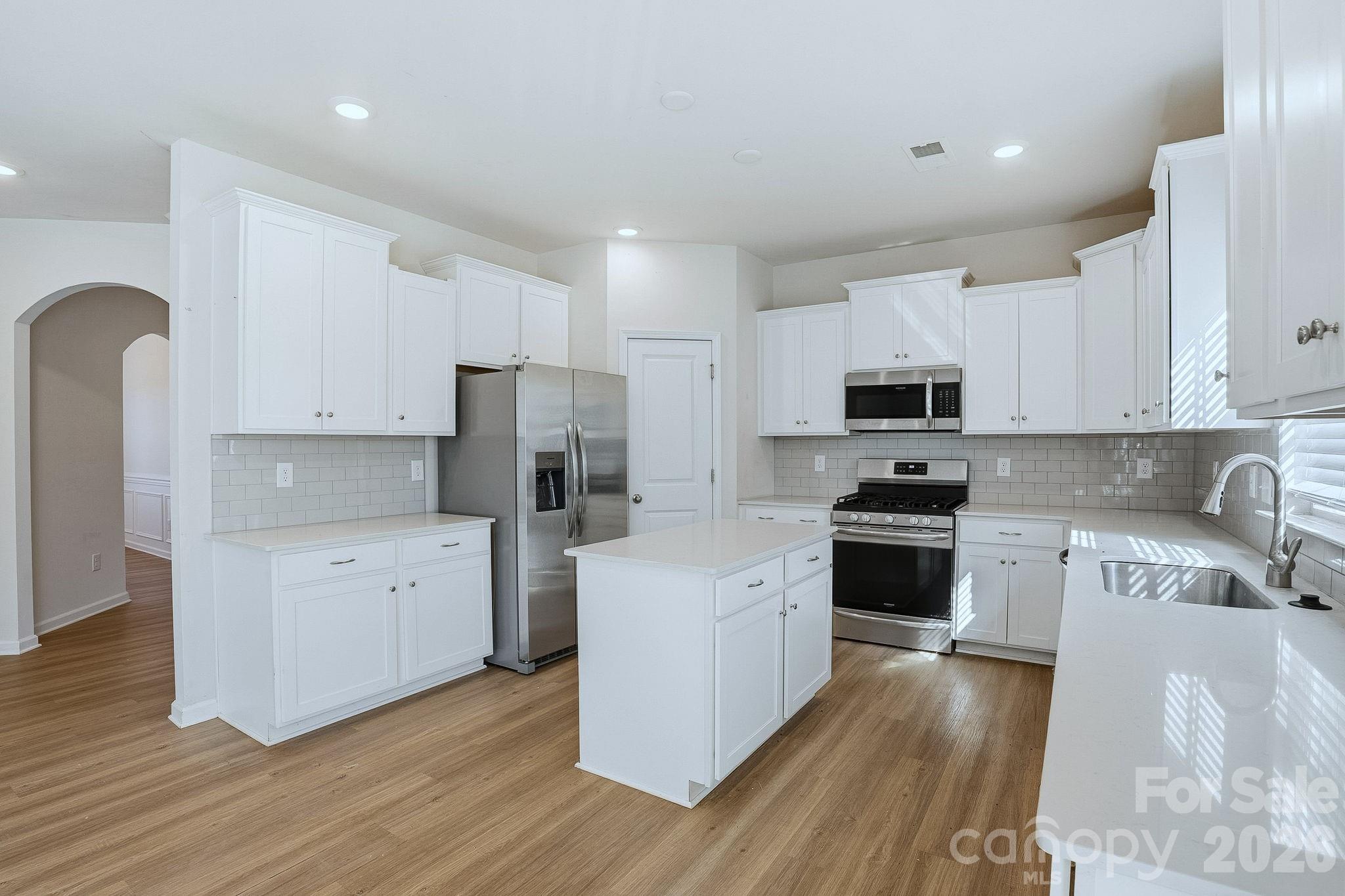 124 Tackle Troutman, NC 28166 - Photo 19 of 44 a kitchen with stainless steel appliances white cabinets a sink a stove a refrigerator and cabinets