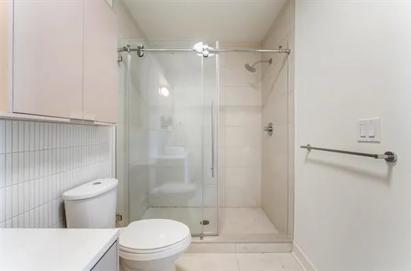 a bathroom with a shower a toilet and sink