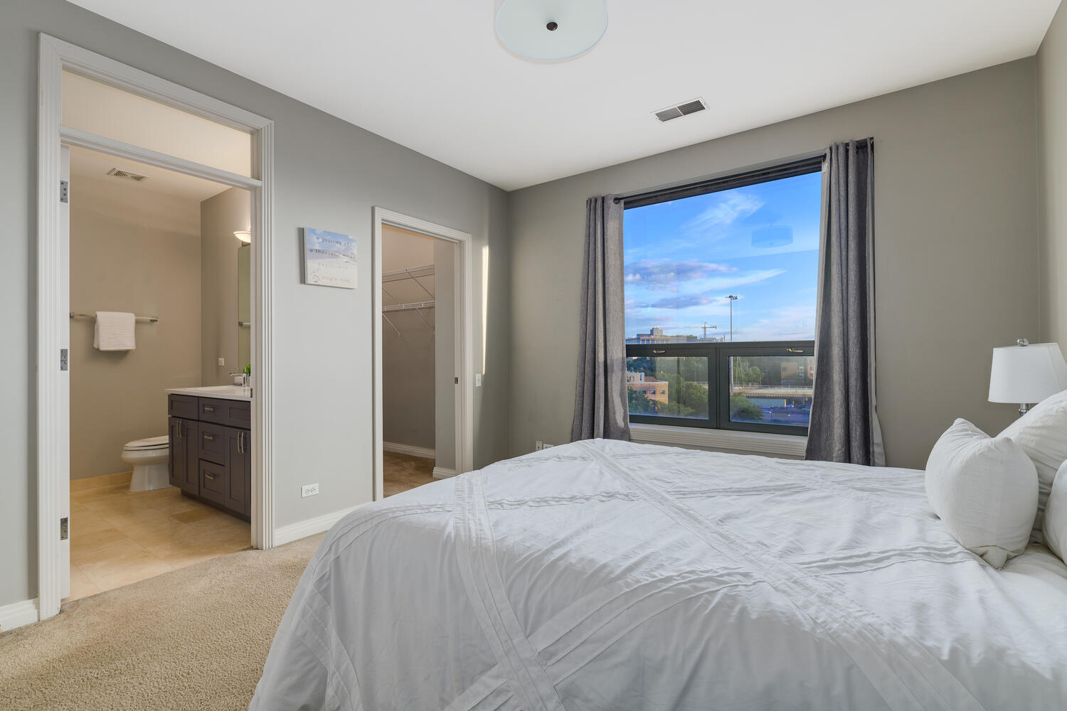 859 West Erie Street, Unit 604 Chicago, IL 60642 - Photo 16 of 32 a bedroom with a large bed and a painting on the wall
