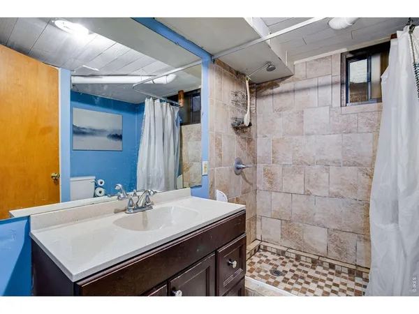 a bathroom with a sink mirror and a shower