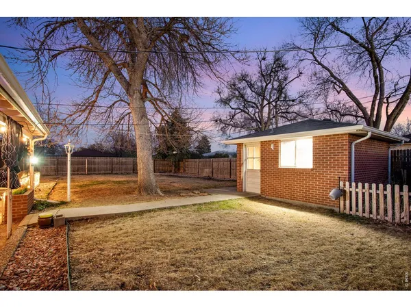 a view of a yard with wooden fence