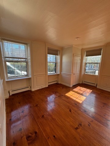 25 State Street, Unit 1 Marblehead, MA 01945 - Photo 5 of 8 an empty room with wooden floor and windows