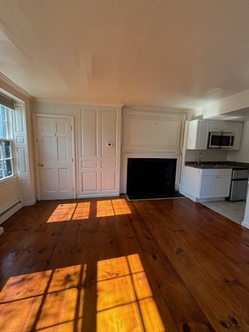 25 State Street, Unit 1 Marblehead, MA 01945 - Photo 7 of 8 a room with wooden floor and fireplace