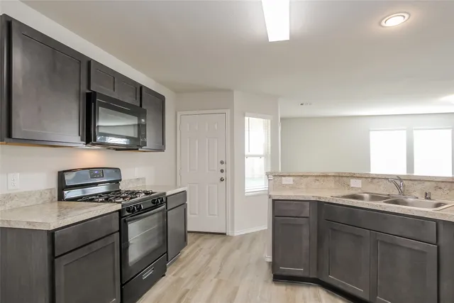 a kitchen with granite countertop a stove and a sink