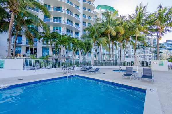 a view of a swimming pool with a patio and a yard