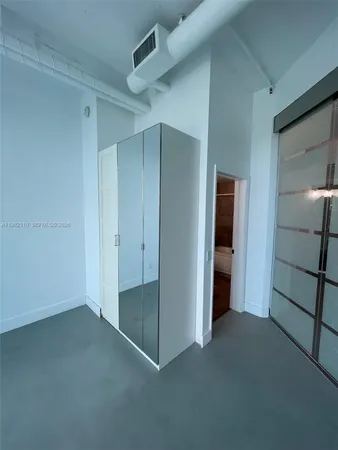 an empty room with windows and closet