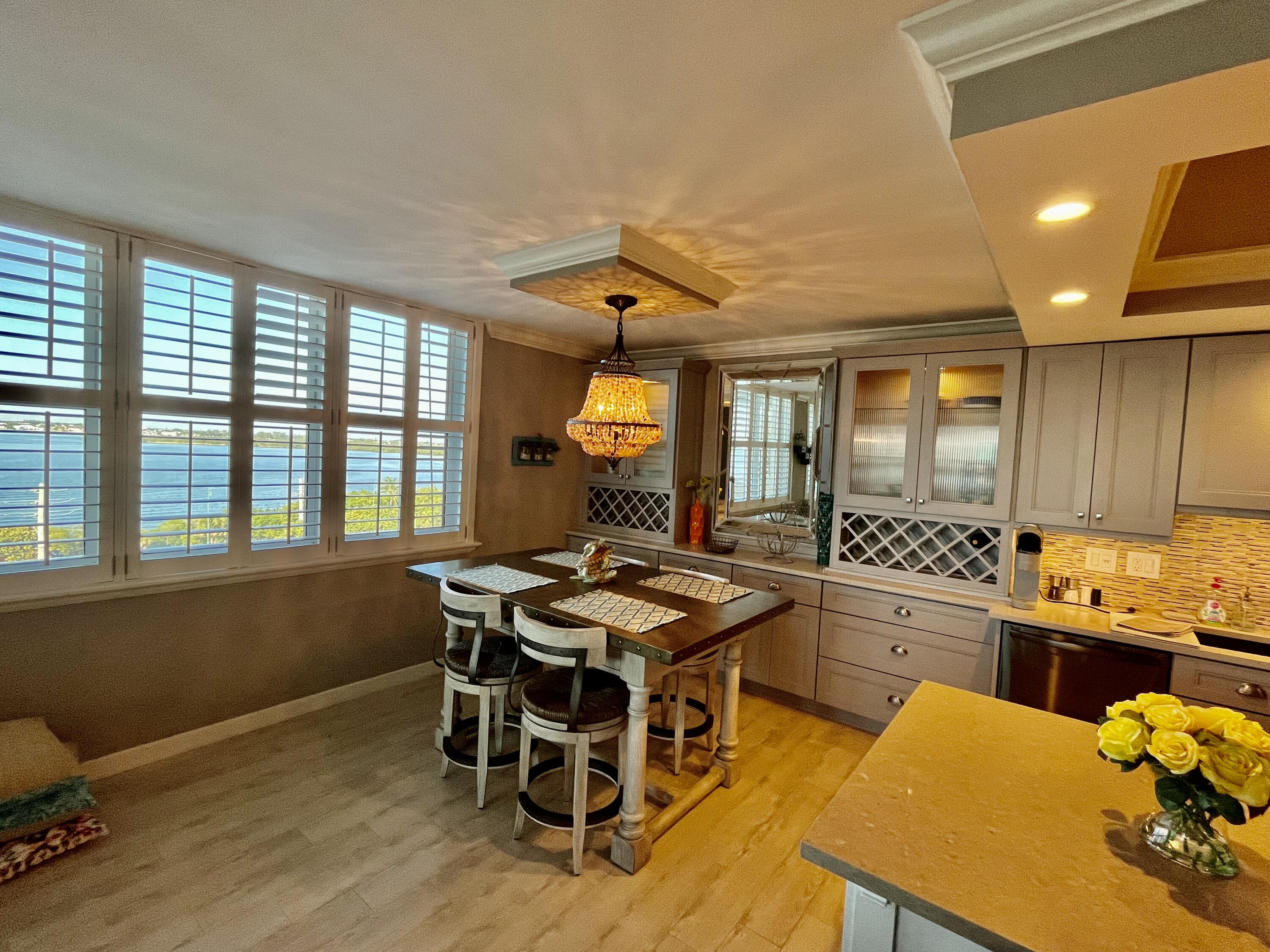 5440 North Ocean Drive, Unit 601 Riviera Beach, FL 33404 - Photo 11 of 55 a kitchen with a table chairs stove and wooden floor