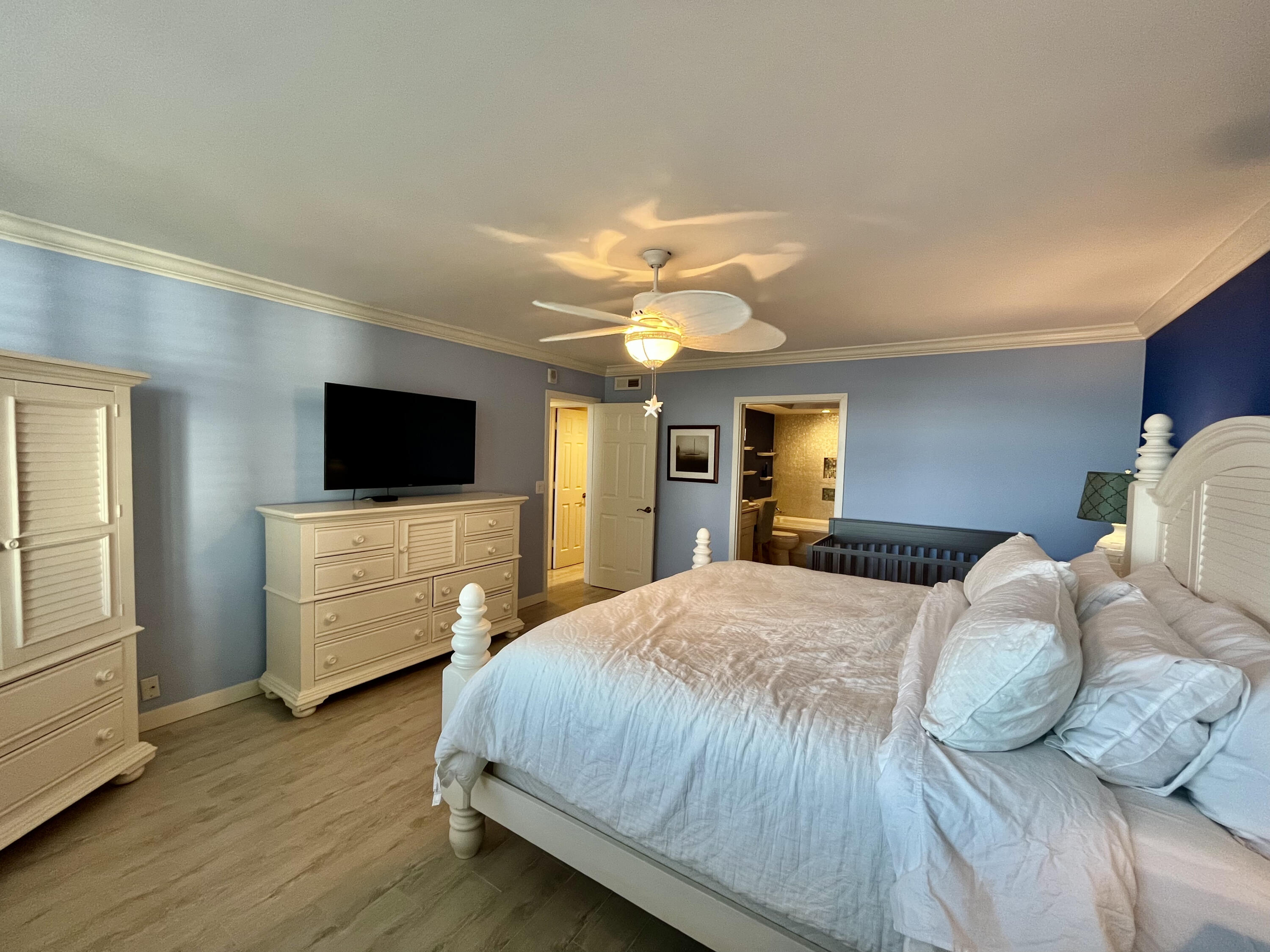 5440 North Ocean Drive, Unit 601 Riviera Beach, FL 33404 - Photo 27 of 55 a bedroom with a bed and a flat tv screen on dresser