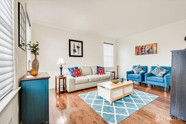 a kitchen with stainless steel appliances granite countertop a refrigerator a sink dishwasher a stove and a dining table with wooden floor