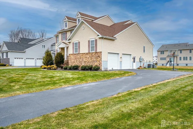 a view of a big house with a big yard and large trees