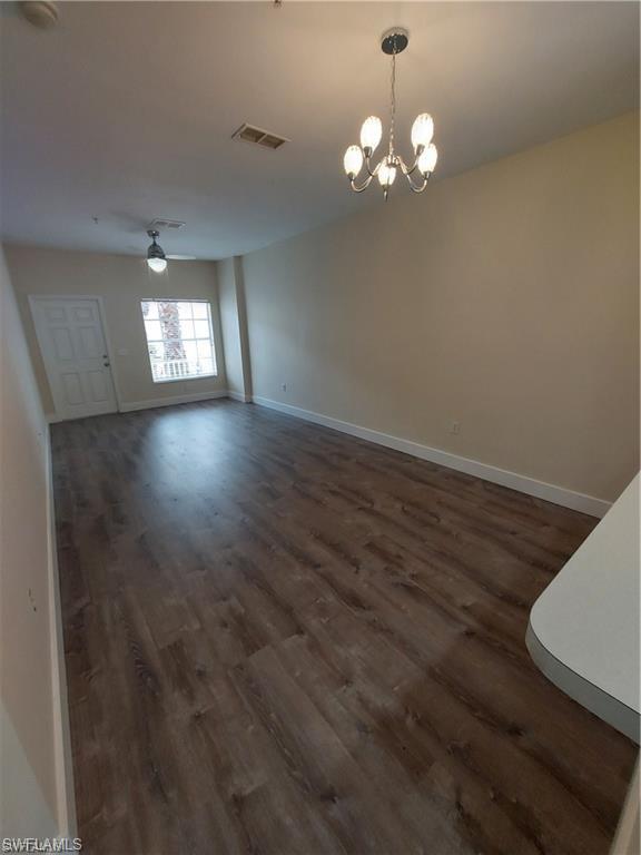 3268 Amanda Lane, Unit 3 Naples, FL 34109 - Photo 22 of 26 a view of a room with wooden floor and chandelier