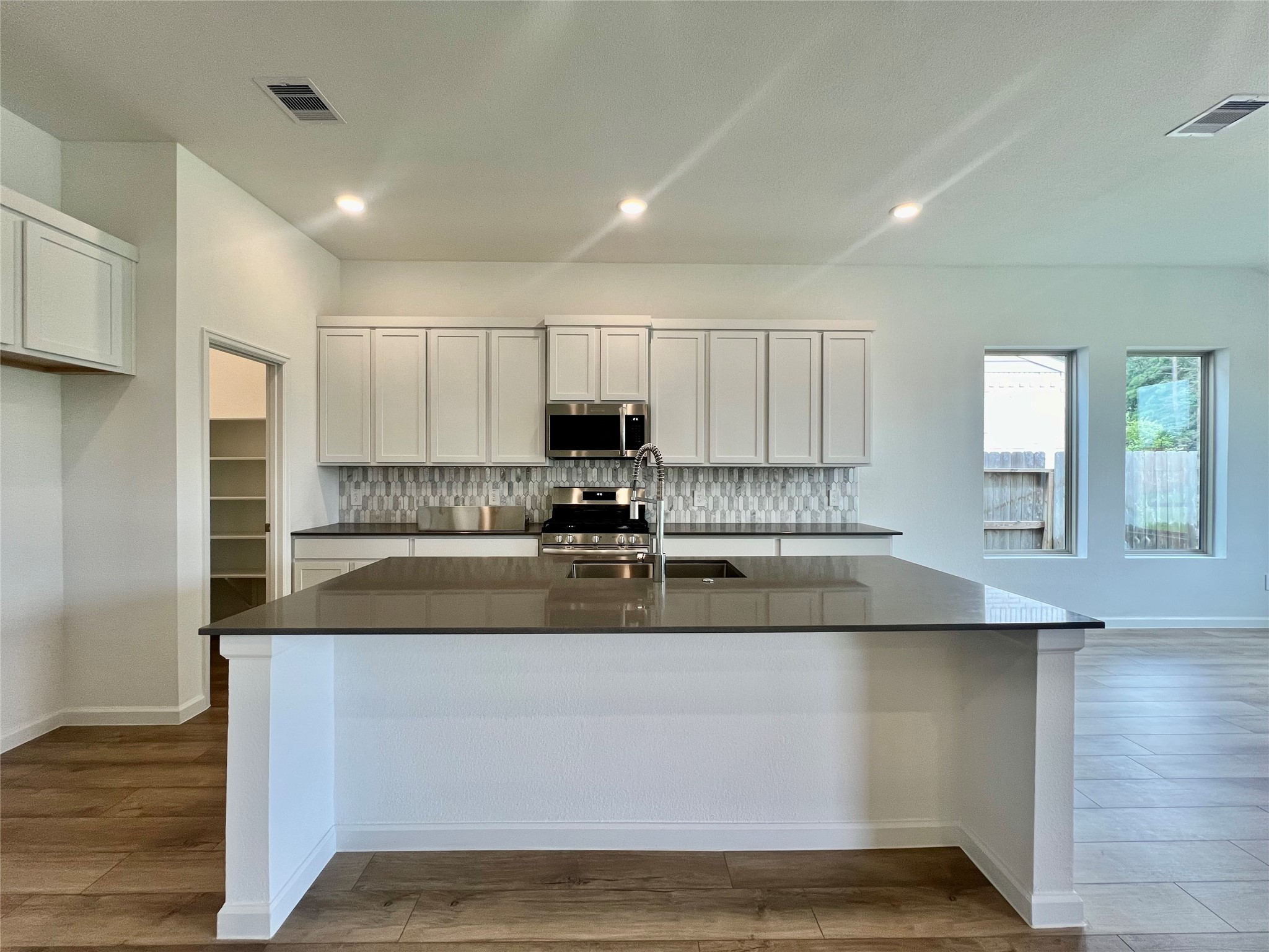17771 Misty Brk Lane Conroe, TX 77302 - Photo 14 of 48 a large kitchen with granite countertop a sink and white cabinets