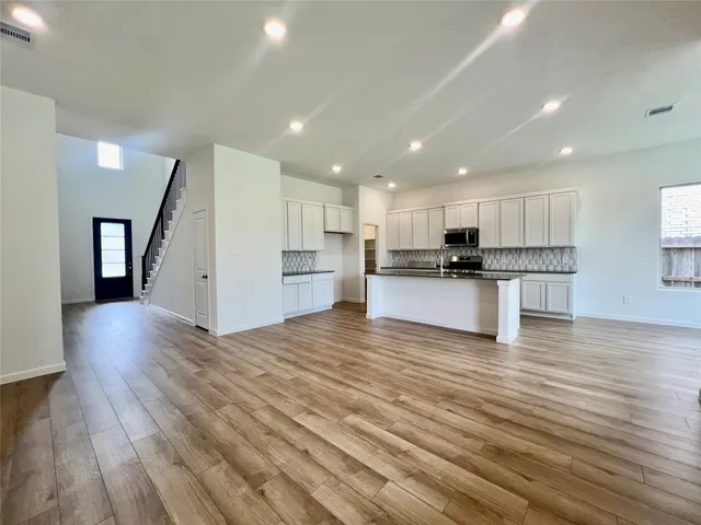 a view of kitchen with cabinets stainless steel appliances with wooden floor